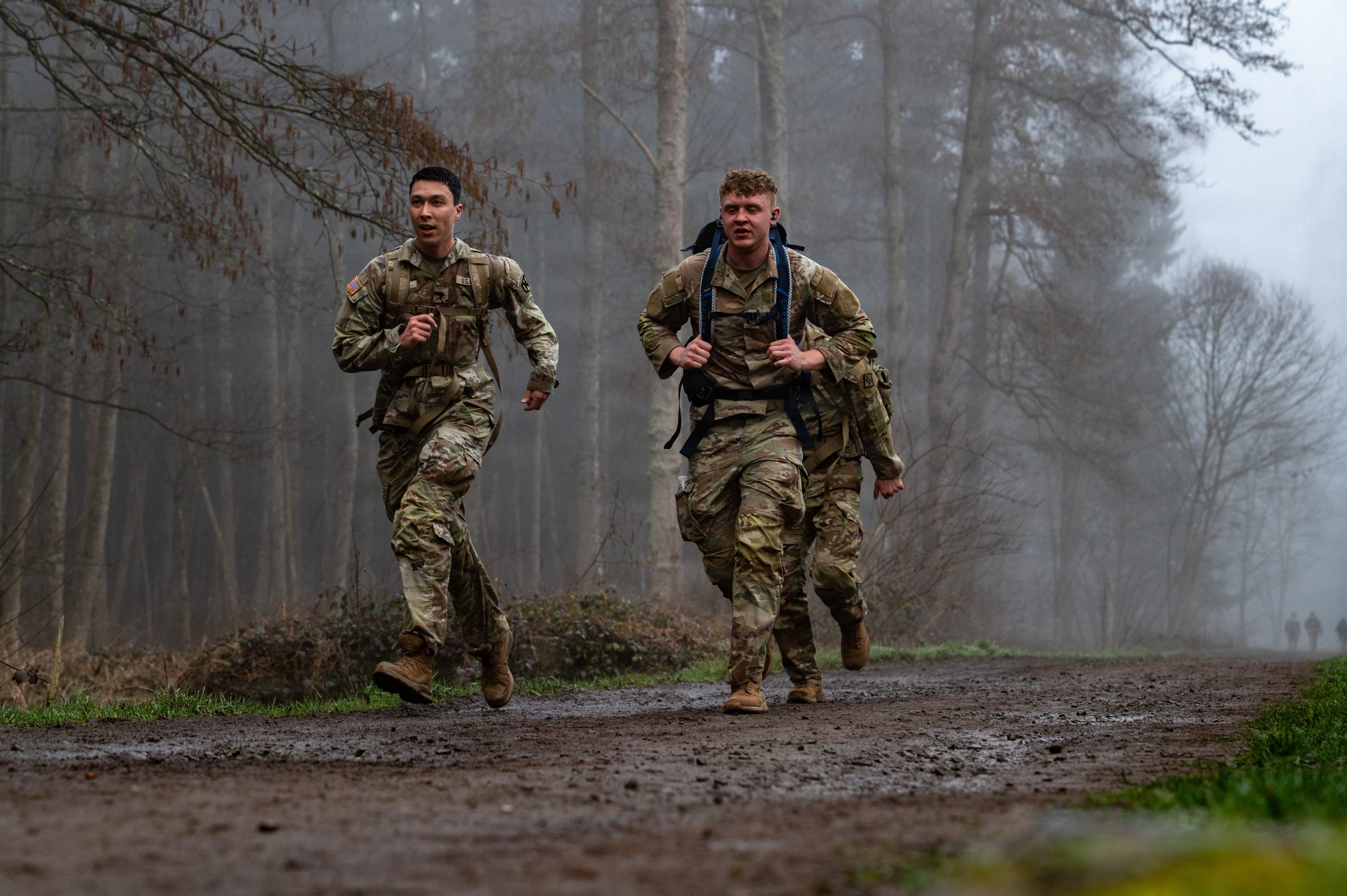 U.S. Air Force Airman 1st Class Christian Kelly, right, 86th Maintenance Squadron aerospace ground equipment apprentice and U.S. Army Specialist Liam Griffin, left, 21st Theater Sustainment Command Special Troops Battalion human resources clerk, runs together during Day 4 rucking during the German and American Friendship Days at Ramstein Air Base, Germany, Feb. 26, 2026. Participants from across the globe took part in the week-long German American Friendship Days hoping to earn the medal in bronze, silver, or gold. By the end of week, 221 badges were awarded to participants who successfully passed each trial in accordance with German military standards. (U.S. Air Force photo by Airman Paden Henry)