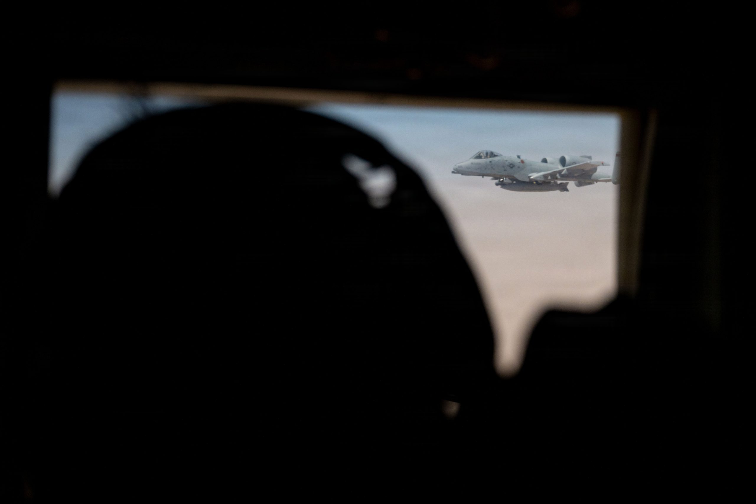A U.S. Air Force loadmaster watches an A-10C Thunderbolt II aircraft approach his HC-130J Combat King II aircraft before conducting aerial refueling in the U.S. Central Command area of responsibility, May 9, 2026. (U.S. Air Force photo)