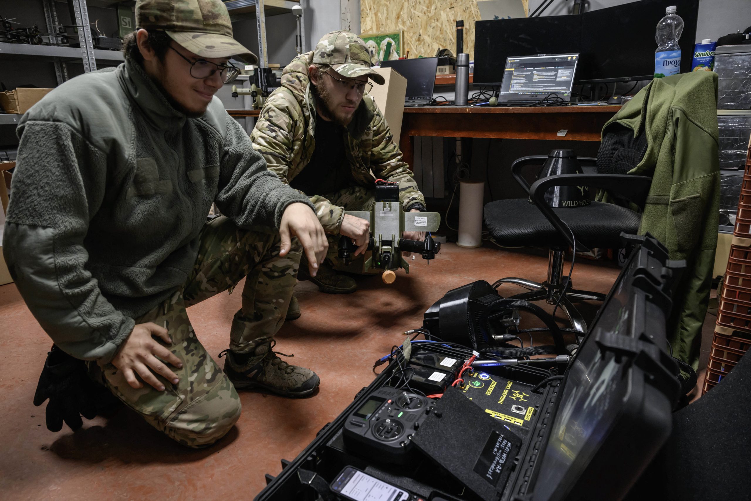 Members of the 3rd Army Corps Interception Squadron check the delivery of a mobile workstation used to control interceptor drones, at an undisclosed location near the front lines of eastern Uraine, on October 9, 2025. (Photo by Ed JONES / AFP via Getty Images)