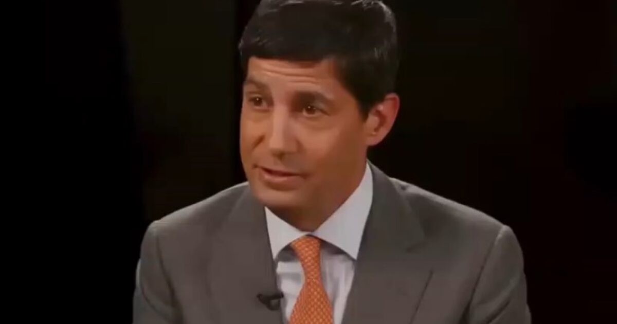 Business professional in a suit speaking during an interview at the Hoover Institution, focusing on economic and policy discussions.