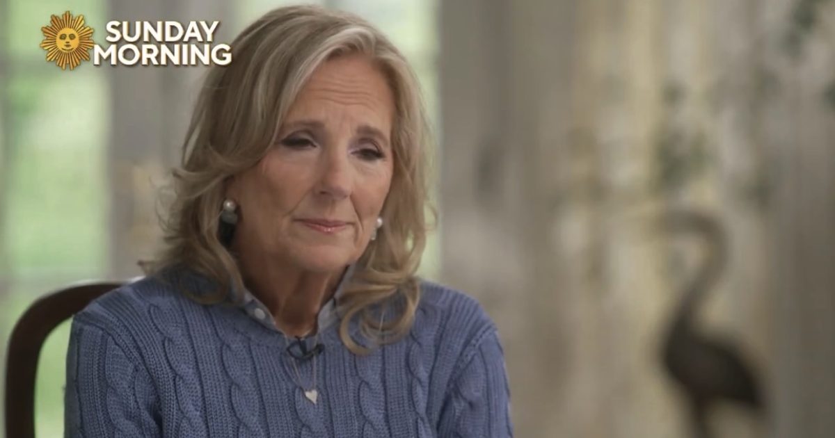 Woman in a blue sweater sitting thoughtfully in a softly lit room, featured on Sunday Morning.