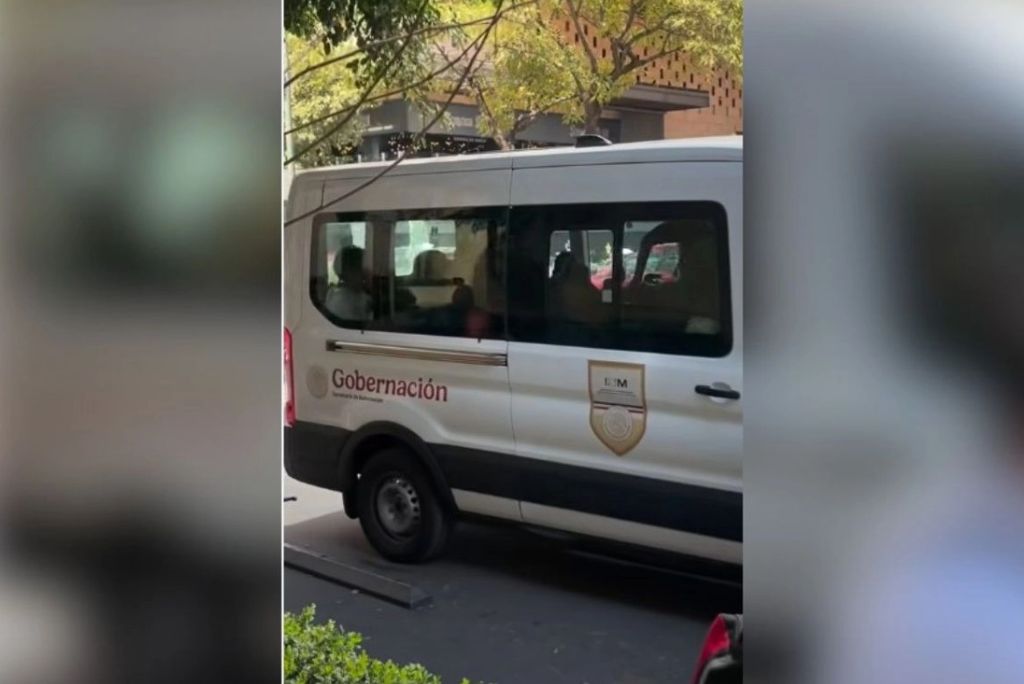 White van with "Gobernación" branding parked on the street, surrounded by trees and urban scenery.