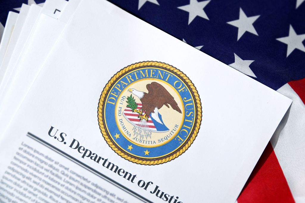 U.S. Department of Justice letterhead with the official seal on a background of an American flag.