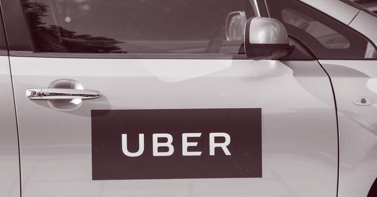 Uber logo displayed on the side of a gray car, representing ride-sharing services and urban transportation options.