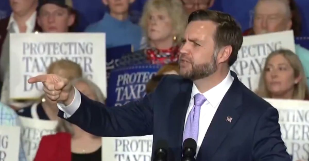 Speaker passionately addresses a crowd at a political rally, emphasizing taxpayer protection with supportive audience members holding signs in the background.