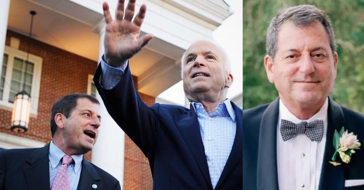 Two men, one waving and smiling, standing outside a building, showcasing a moment of camaraderie and celebration.