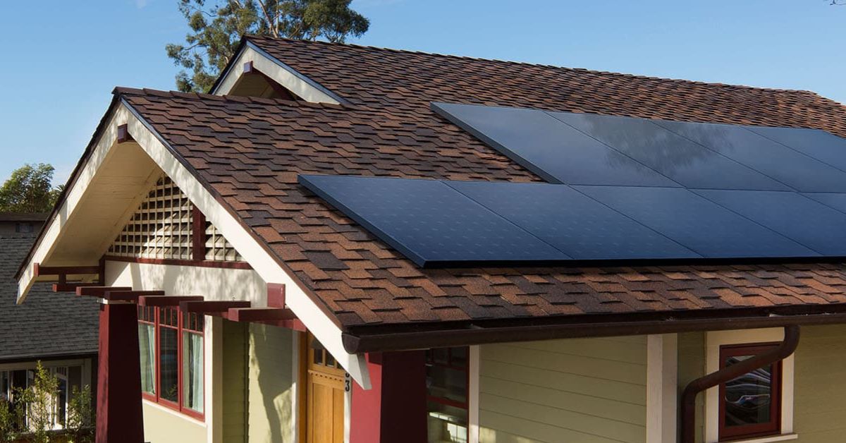 Solar panels installed on a modern home roof, showcasing sustainable energy solutions and stylish architecture against a clear blue sky.