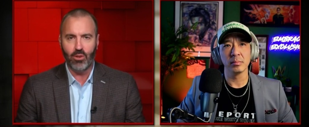 Two men engage in a discussion on a video call, featuring a red background and various decorative elements in the setting.