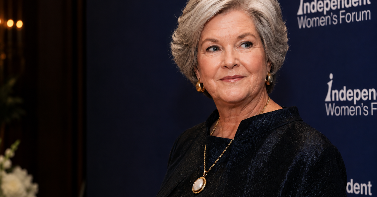 Woman with short gray hair wearing a dark outfit and pearl necklace, posing at the Independent Women’s Forum event backdrop.