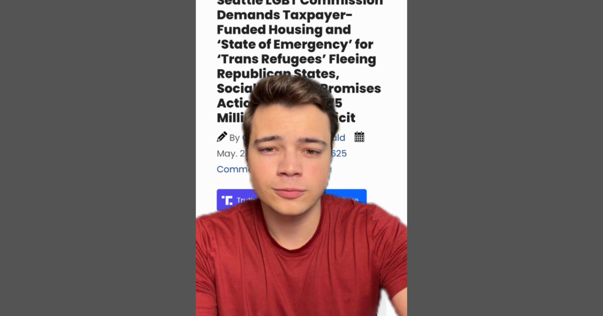 Person in a red shirt with a serious expression, in front of a news article about Seattle LGBT Commission's demands for housing for trans refugees.