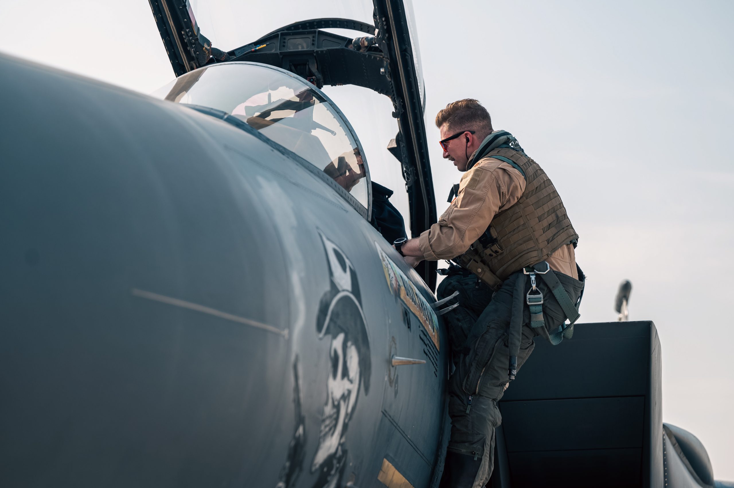 U.S. Air Force Capt. Johnson, a pilot assigned to the 391st Expeditionary Fighter Squadron, climbs into the cockpit of an F-15E Strike Eagle during exercise Agile Spartan 25.2 in the U.S. Central Command area of responsibility Aug. 26, 2025. U.S. Air Forces Central's ability to rotate a combat-capable fighter presence throughout the theater complicates the adversary’s decision-making and targeting processes against the U.S. forces in the region. (U.S. Air Force photo by Senior Airman Grace Turpin)