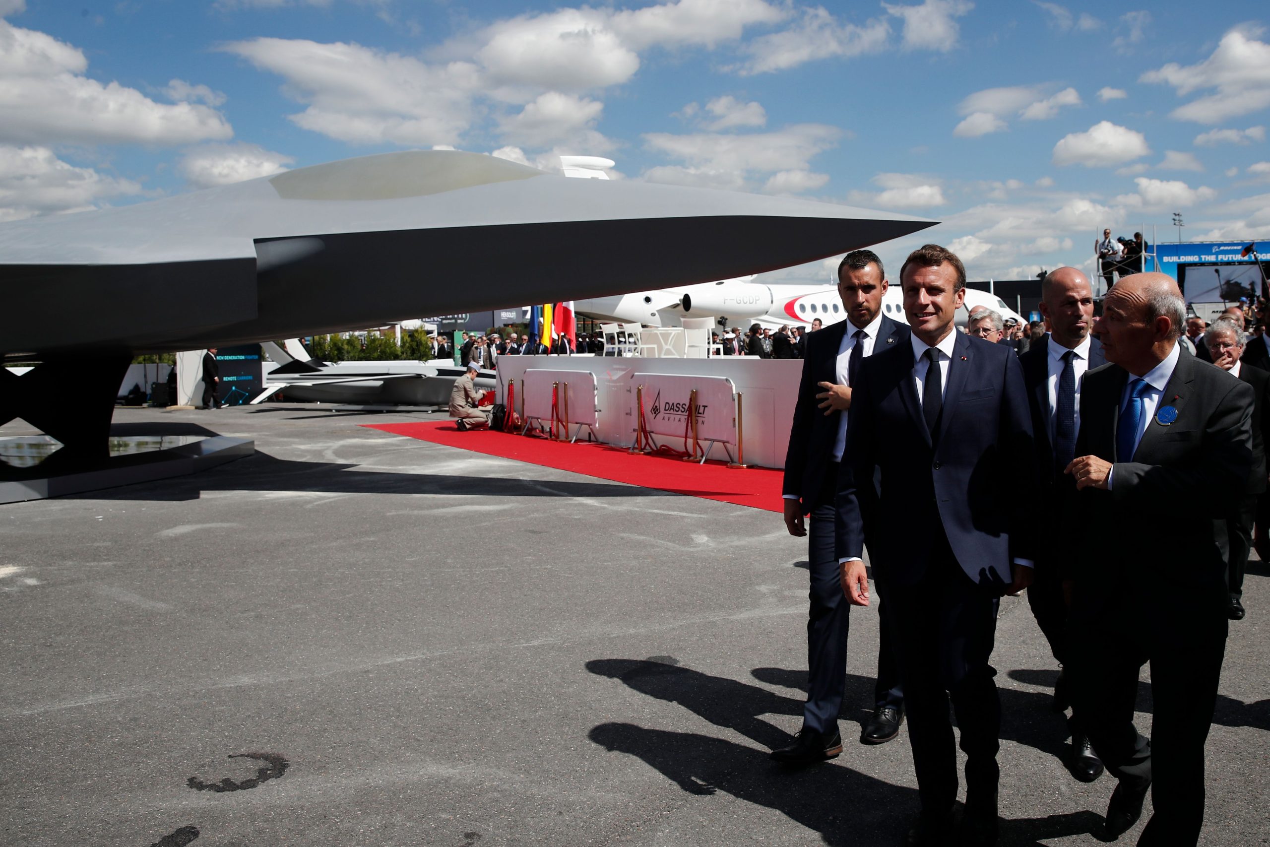 French President Emmanuel Macron talks with Eric Trappier, Chairman and CEO of Dassault Aviation, after the unveiling of the full-scale jet fighter model of the Systeme de Combat Aerien Futur (SCAF), the French-German-Spanish new generation Future Combat Air System (FCAS), during the 53rd International Paris Air Show at Le Bourget Airport near Paris, on June 17, 2019. (Photo by BENOIT TESSIER / POOL / AFP) (Photo credit should read BENOIT TESSIER/AFP via Getty Images)