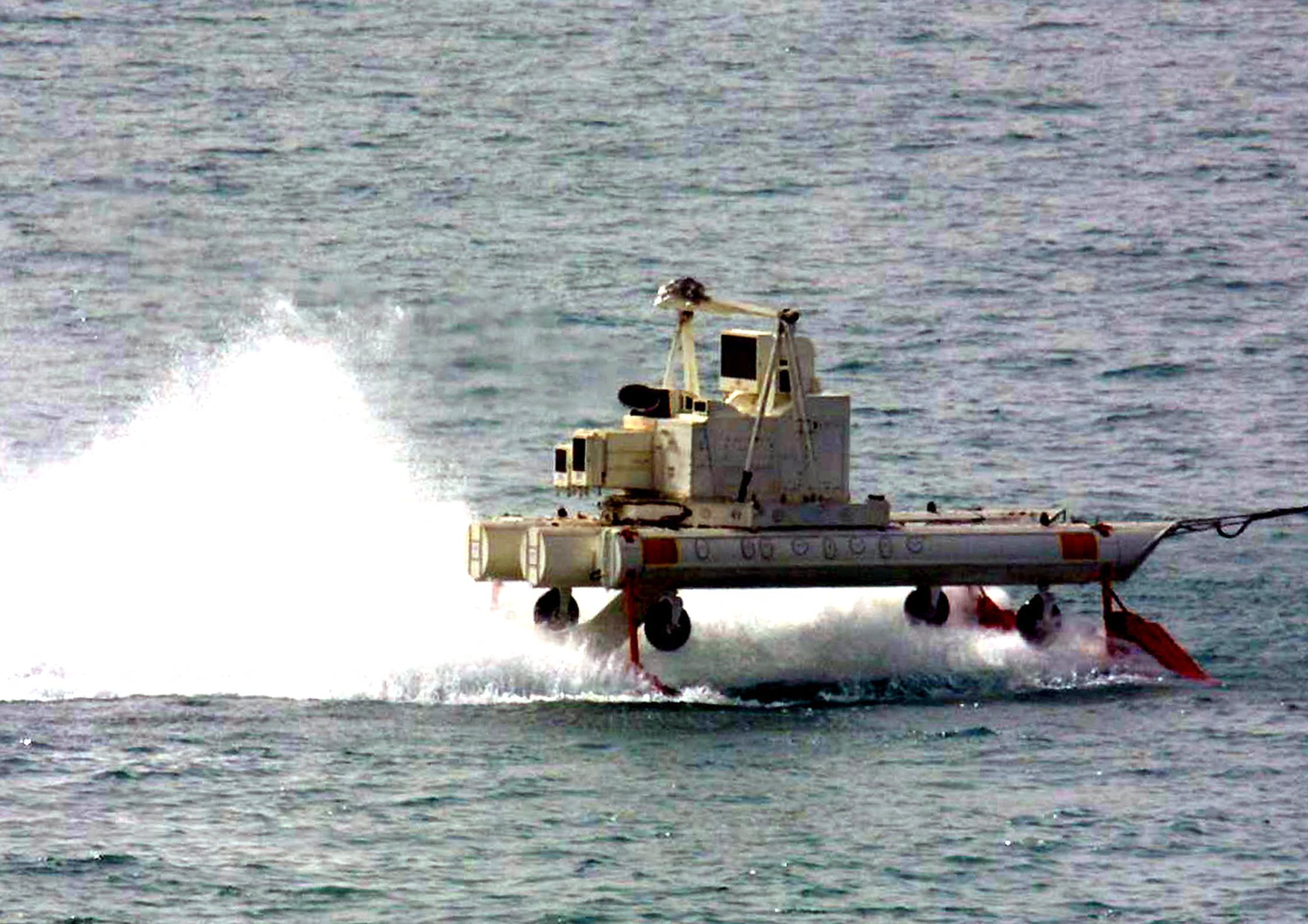 A US MH-53E military helicopter using a cable drags an MK 106 Combination sent out from the USS Ponce as mine clearance takes place in Khor Abdullah at the entrance to Umm Qasr port in the western Gulf 29 March 2003. Sharp differences have emerged between the United States and Britain on who should rebuild Iraqi port Umm Qasr after the war, as non-US firms have been almost completely excluded from the tenders process. Umm Qasr is Iraq's only deep-water seaport on its short Gulf coastline, which lies on the western side of the Fao Peninsula 460 kilometers (280 miles) south of Baghdad. AFP PHOTO/Rabih MOGHRABI (Photo by RABIH MOGHRABI / AFP) (Photo by RABIH MOGHRABI/AFP via Getty Images)