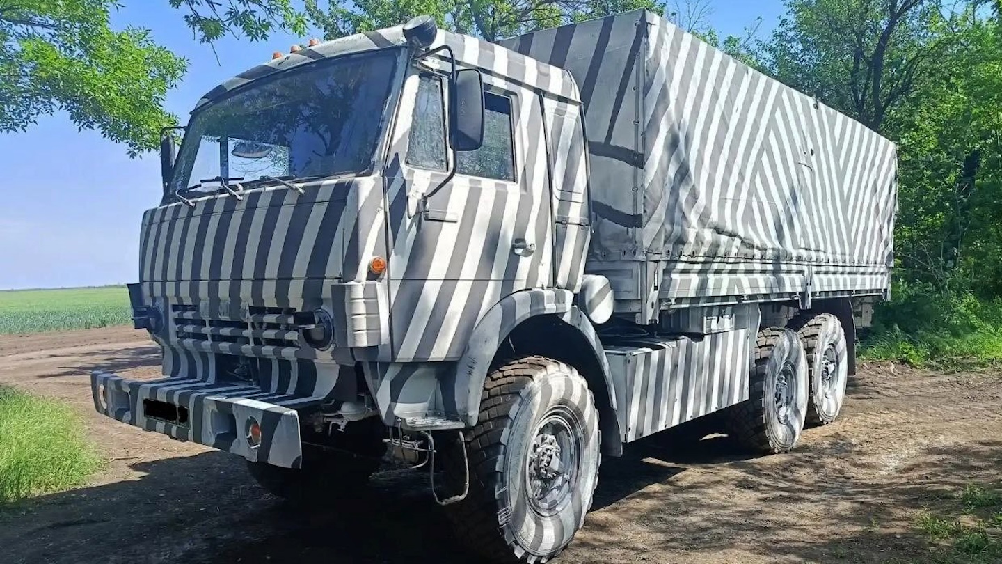 Several images showing the unusually painted Russian trucks have appeared on social media channels in recent days. So far, examples of Ural and KAMAZ heavy-duty truck designs have appeared. There are at least two distinct patterns so far: a zebra-style application of broadly straight lines, and a more organic leaflike, swirling design. In both cases, they extend over most external surfaces, including the wheels and tires. The white paint is simply applied over the base color of dark green.