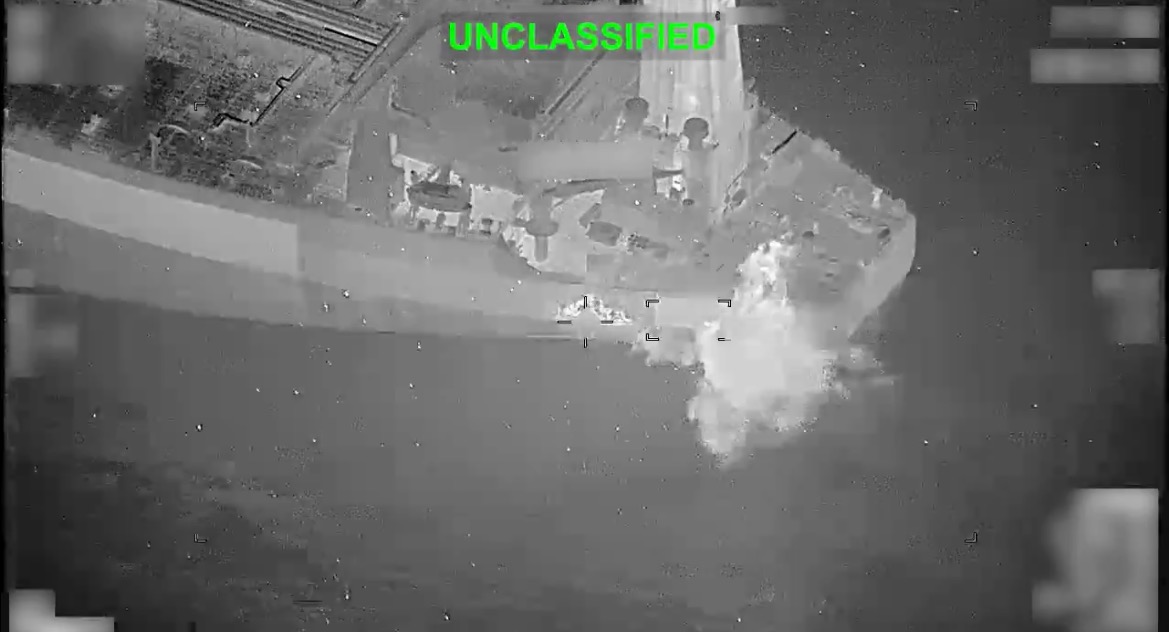 Aerial view of an unclassified military operation showing a vessel engaged in an explosion at sea.