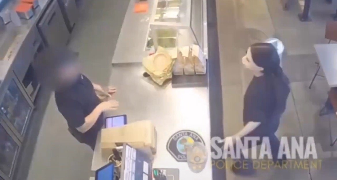 Surveillance footage shows a customer interacting with a cashier in a restaurant setting, highlighting a moment of communication at the counter.