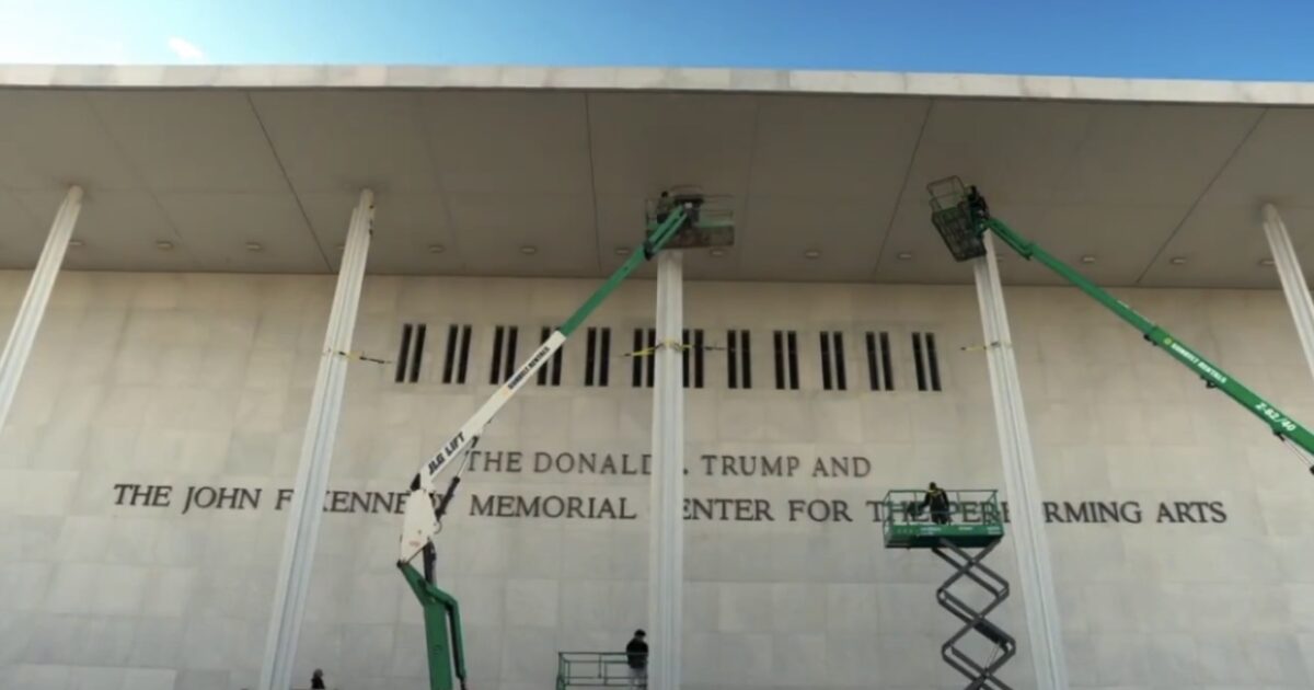 Workers using lifts to perform maintenance on the exterior of the John F. Kennedy Center for the Performing Arts in Washington, D.C.