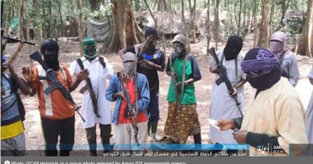 Group of masked individuals holding firearms in a forest setting, associated with militant activities.
