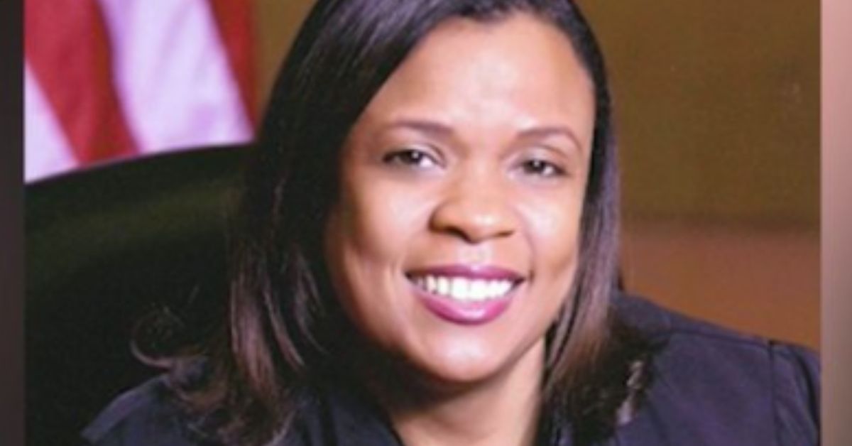 Smiling professional woman in front of an American flag background, showcasing a confident and approachable demeanor.