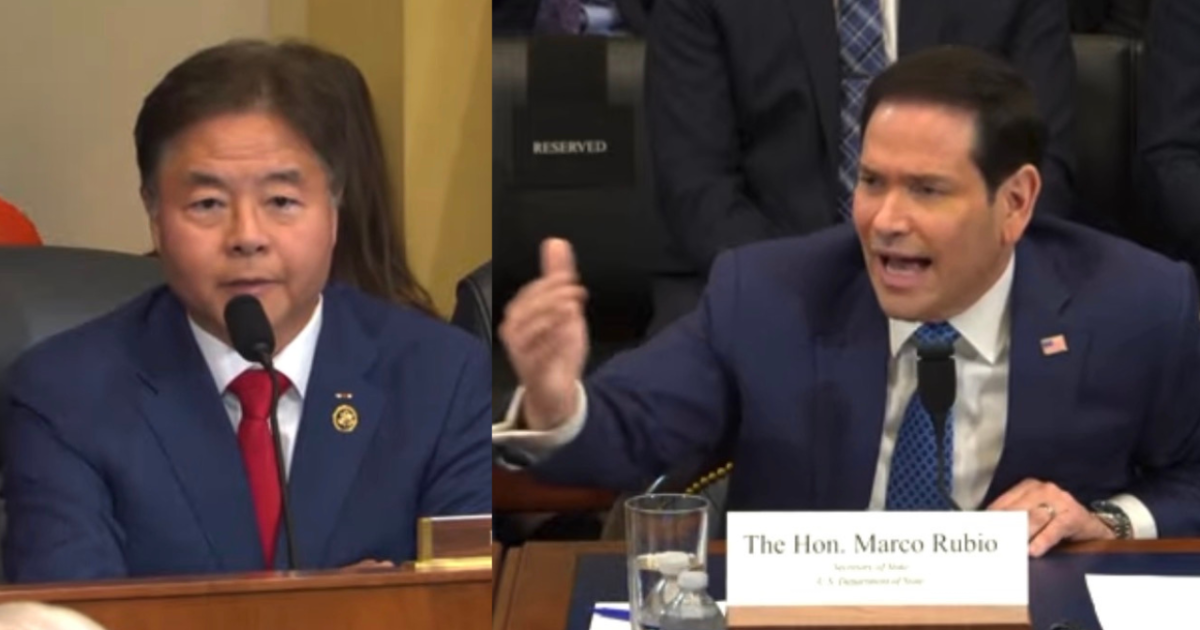 Two U.S. lawmakers, one speaking calmly and the other passionately gesturing, engage in a congressional hearing setting.