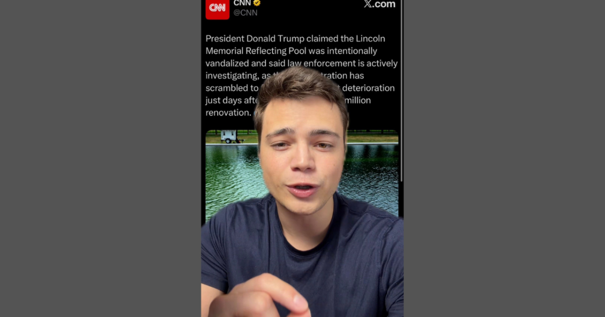A young man speaks in front of a reflective pool, discussing allegations of vandalism at the Lincoln Memorial Reflecting Pool following recent renovations.